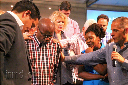 教会同工在为奇贝尔祷告